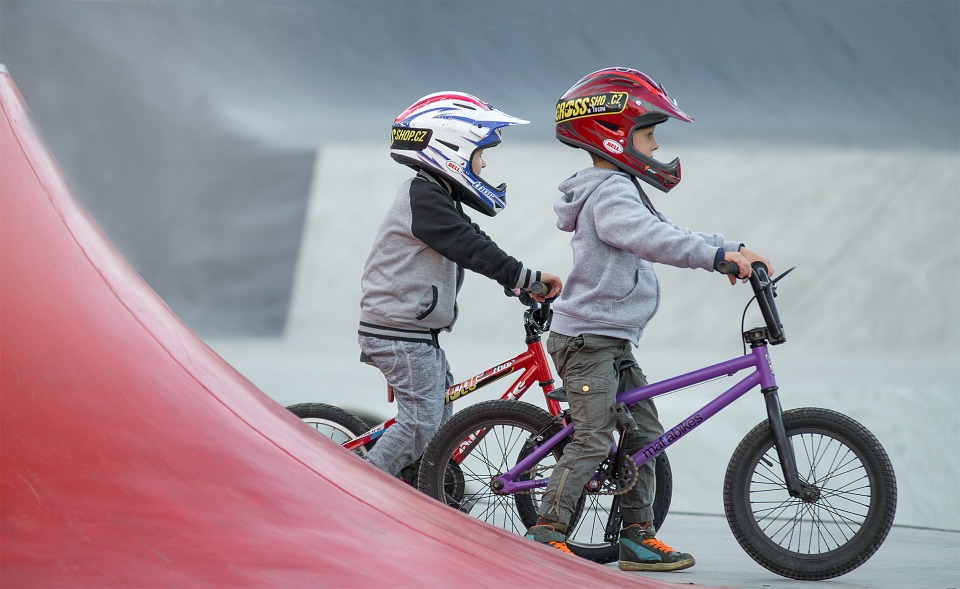 Bambini nello skatepark in sella a biciclette BMX
