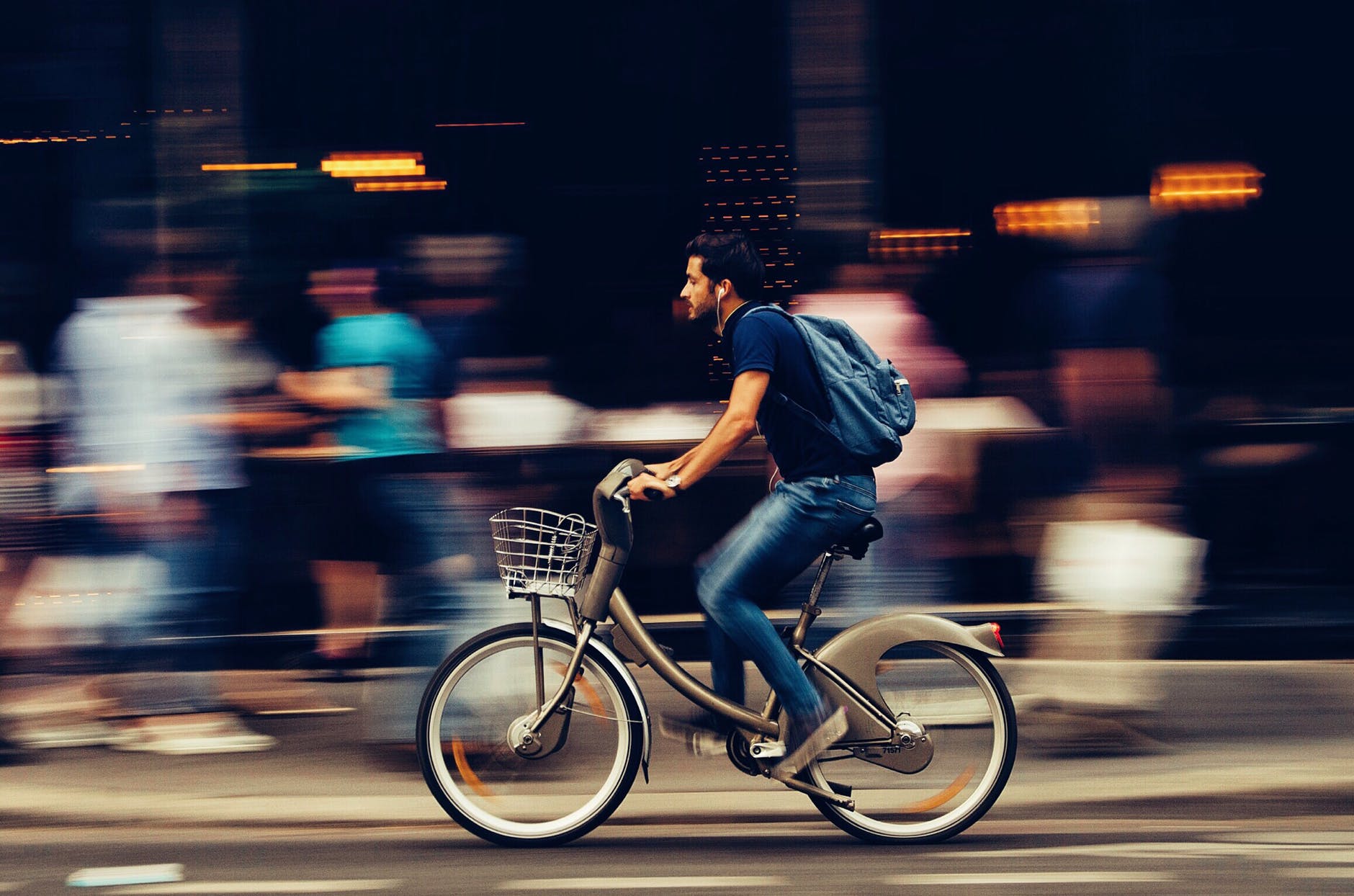 Seorang pria mengendarai sepeda elektronik di kota